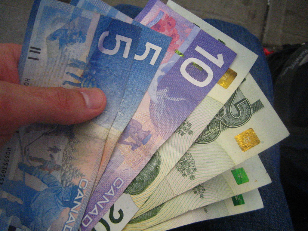 Manos sosteniendo billetes de dólar